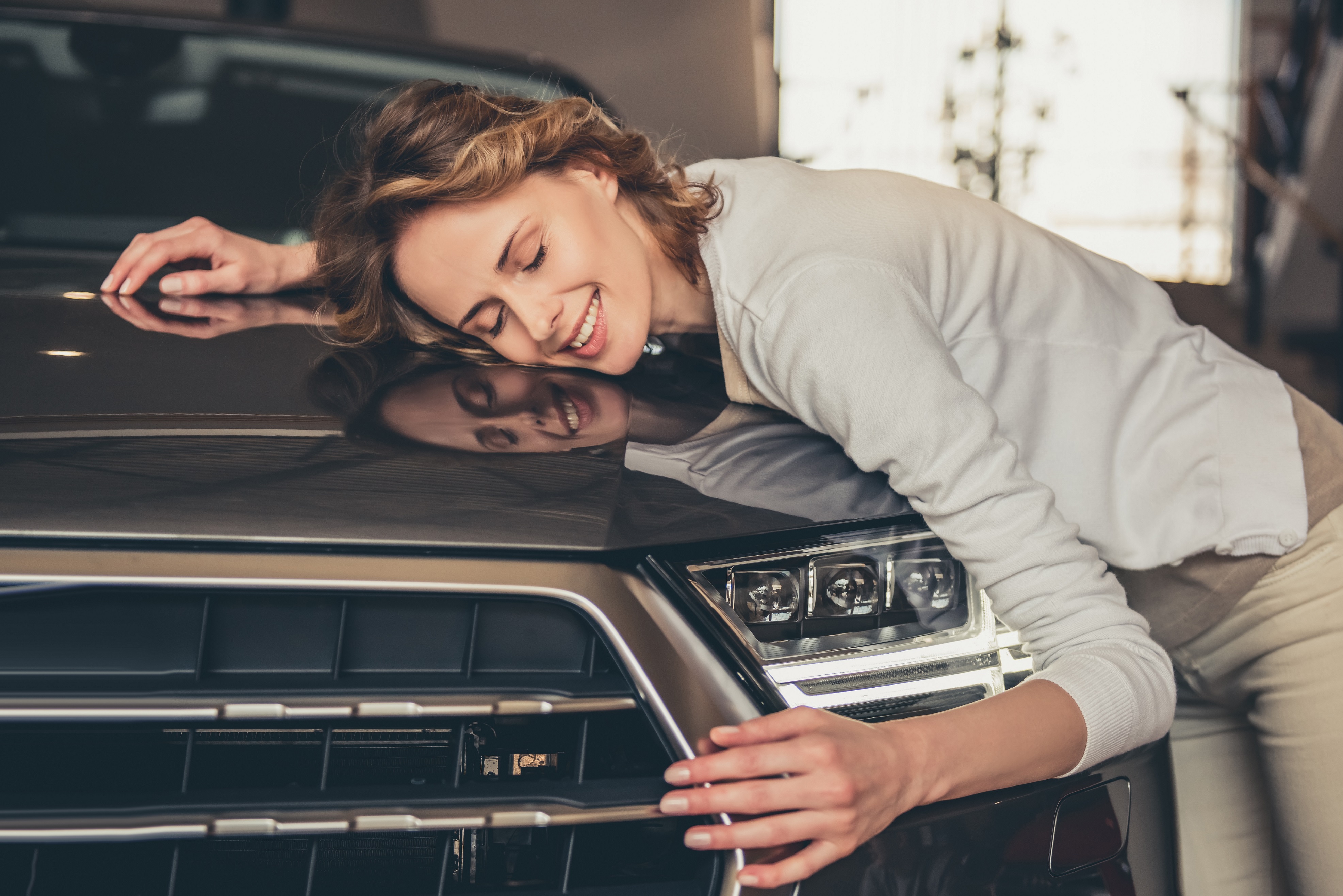 Young woman hugging car