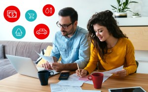 A man and a woman manage their bills sitting at a desk